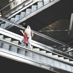 Woman-checking-phone-on-escalator