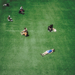 high-angle-image-of-people-sitting-on-fake-grass
